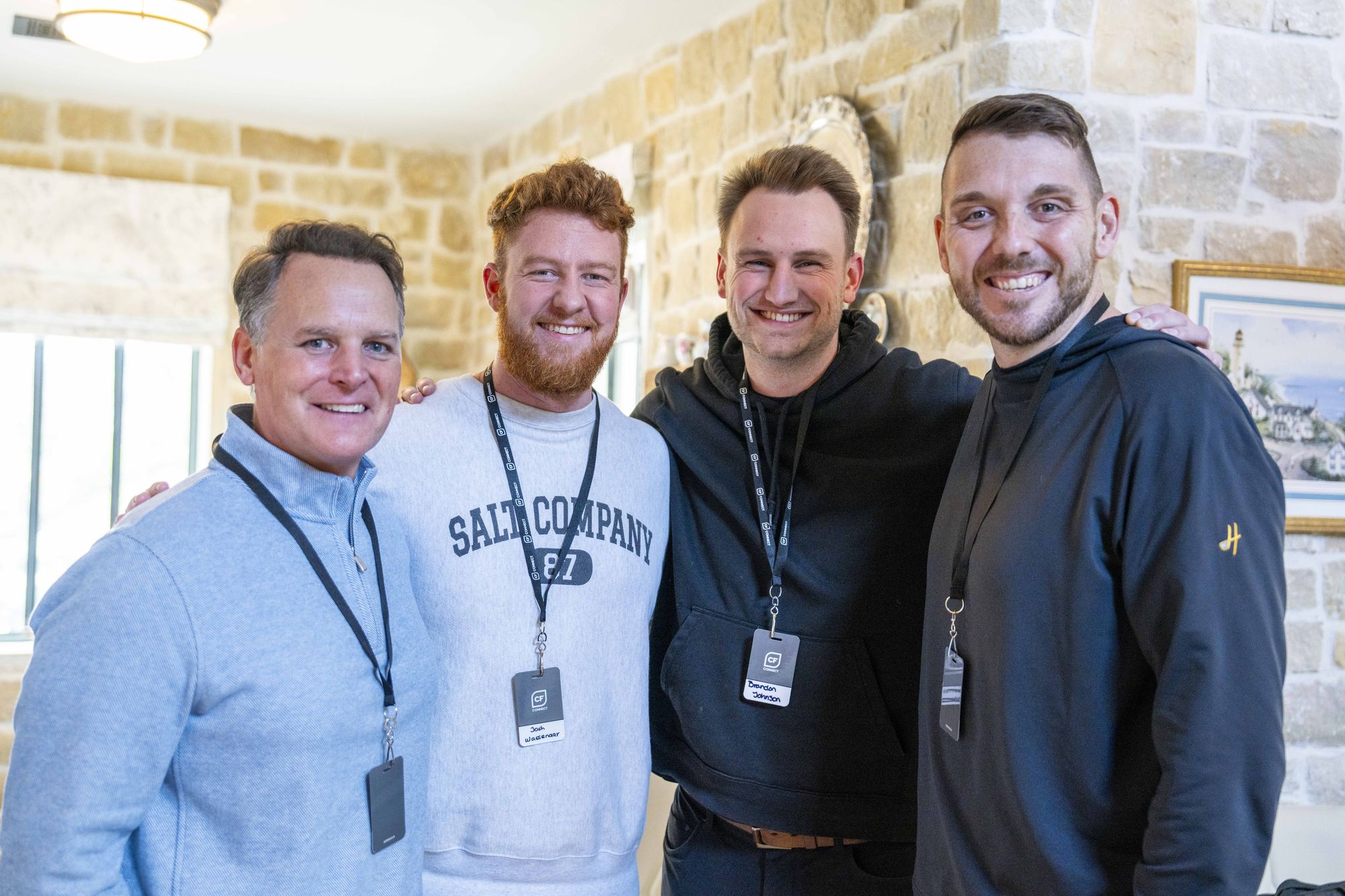 Steven Smith smiling arm in arm with three young pastors in a stone-walled room